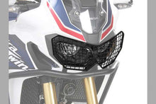 Honda Africa Twin headlight guard with rugged black grill for protection and off-road style.