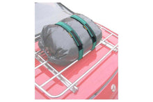 Stretchable bungee straps securing luggage on car roof rack.